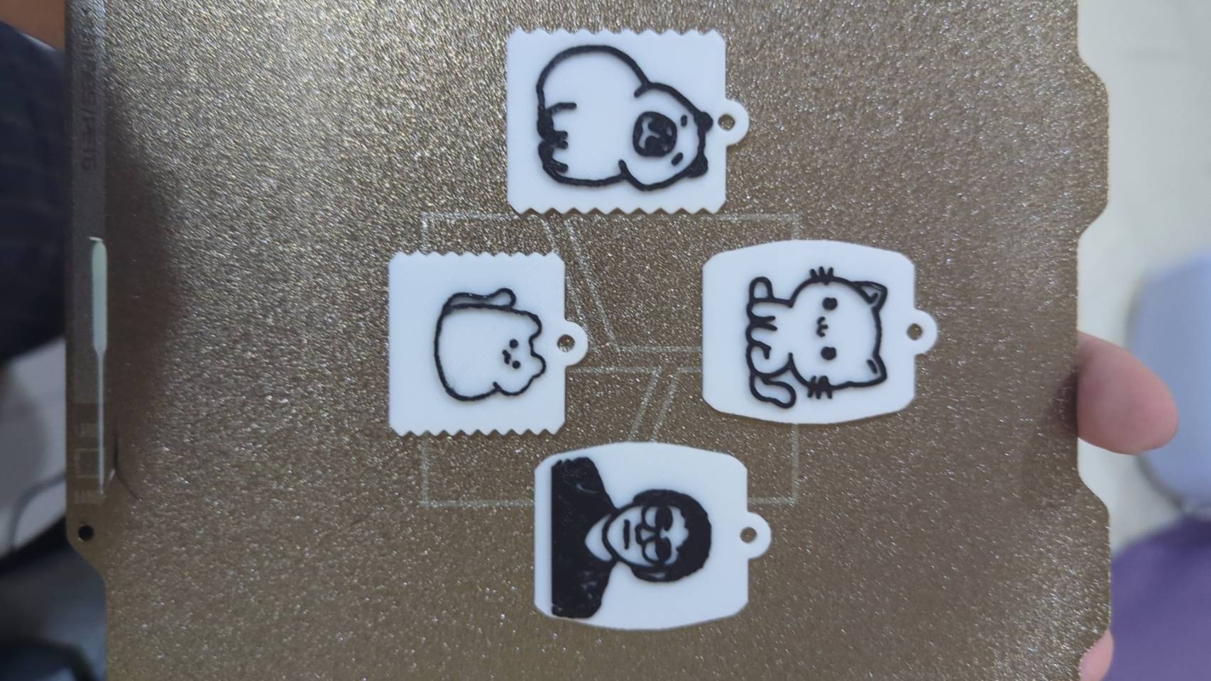 黑白雙色客製吊飾實拍，展示動物圖案與人像，以及圓角和郵票邊框